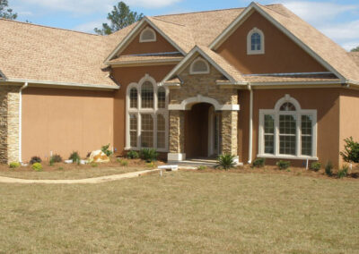 an stucco and stone single-family home with a landscaped front yard.