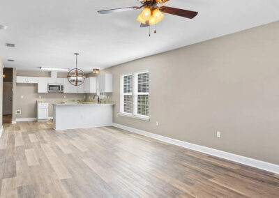 Open concept living area with wood-look flooring and a partial view of the kitchen.