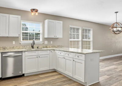 Modern kitchen with white cabinets, granite countertops, and stainless steel appliances.