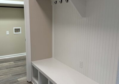 A white built-in mudroom bench with four cubby compartments